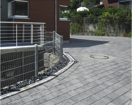 Vue extérieure avec pavés, clôtures et plantations