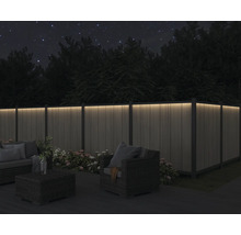 Terrasse mit beleuchtetem Zaun und Sitzgruppe bei Nacht