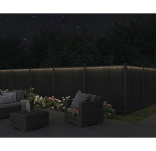 Gartenmöbel-Set auf Terrasse mit beleuchtetem Zaun bei Nacht