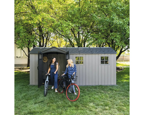 Gartenschuppen mit zwei Frauen und Fahrrädern auf Rasen