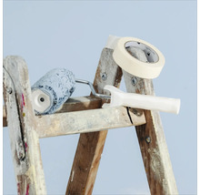 Peinture et accessoires sur une échelle : rouleau à peinture, ruban de masquage