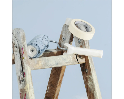Peinture et accessoires sur une échelle : rouleau à peinture, ruban de masquage