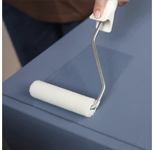 Une personne utilise un rouleau à peinture pour peindre une surface en bois