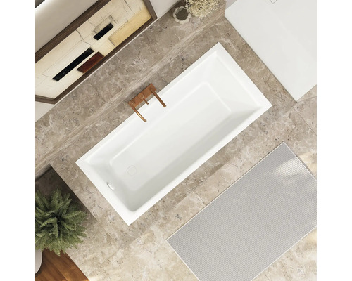 Salle de bains avec baignoire, robinetterie, décoration et tapis de bain