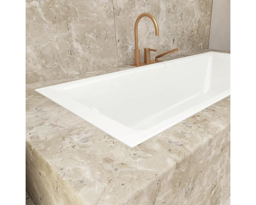 Baignoire blanche avec robinetterie sur plaque de marbre