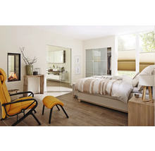 Chambre lumineuse avec lit, fauteuil, cheminée et accès à la salle de bain