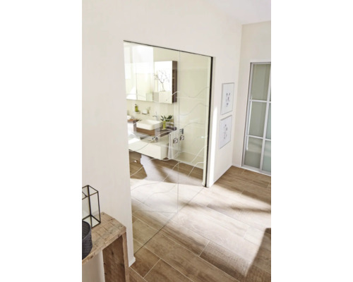 Salle de bain lumineuse avec porte coulissante en verre et lavabo