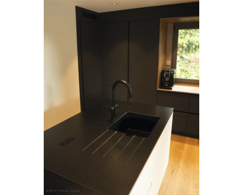 Scène de cuisine avec évier, robinet et appareils de cuisine devant la fenêtre