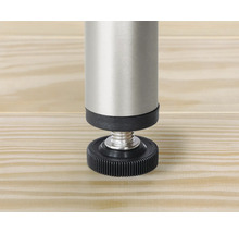 Detailansicht eines verstellbaren Möbelfußes aus Metall und Kunststoff auf einer Holzoberfläche.