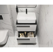 Salle de bains moderne avec lavabo blanc et meuble sous-vasque avec tiroir ouvert pour les accessoires de salle de bains