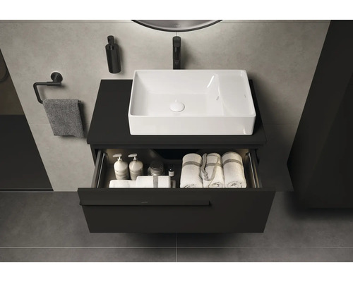 Waschbeckenunterschrank mit geöffneter Schublade, darin Badutensilien und Handtücher