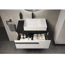 Modernes Badezimmer mit Waschbecken, schwarzer Arbeitsplatte und offenem Schubfach zur Aufbewahrung von Badutensilien