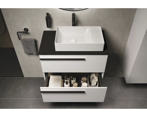 Badezimmer mit Waschtischunterschrank, Aufsatzwaschbecken und geöffneter Schublade mit Handtüchern und Badezimmerutensilien