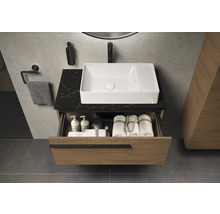 Meuble sous-lavabo avec tiroir ouvert, lavabo et accessoires dans la salle de bain