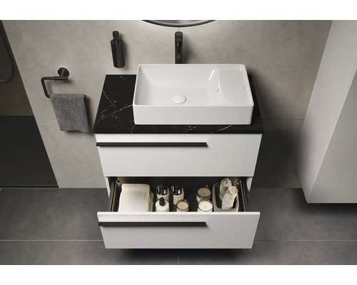 Meuble-lavabo de salle de bain avec tiroir ouvert, vasque à poser blanche et plateau en marbre noir
