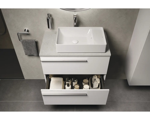 Modernes Badezimmer mit Waschbecken, Unterschrank mit offener Schublade und Badutensilien.