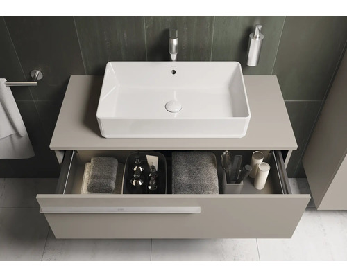 Badezimmeransicht mit Waschbecken und offenem Schubladenfach unter der Arbeitsplatte, in der Handtücher und Badutensilien aufbewahrt werden.