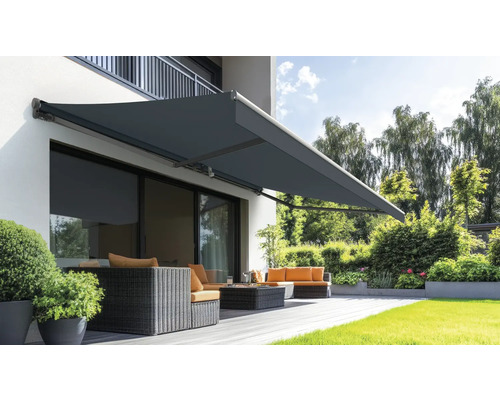 Store banne déployé faisant de l'ombre sur la terrasse avec mobilier de jardin.