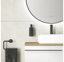 Salle de bain avec miroir rond, lavabo, robinet, distributeur de savon et porte-serviettes