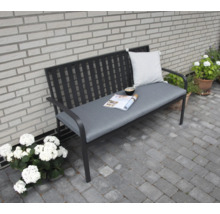 Banc de jardin avec coussin et revêtement devant un mur