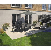 Scène de jardin avec table à manger, chaises, parasol et chaises longues sur une terrasse.