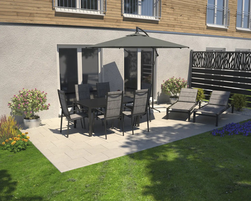 Scène de jardin avec table à manger, chaises, parasol et chaises longues sur une terrasse.