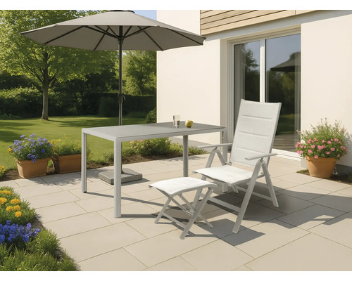 Scène de jardin avec table, chaise, repose-pieds et parasol sur une terrasse