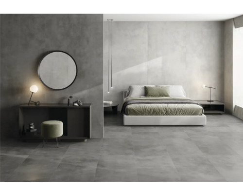 Chambre moderne avec lit double, table de chevet, miroir et carrelage gris.