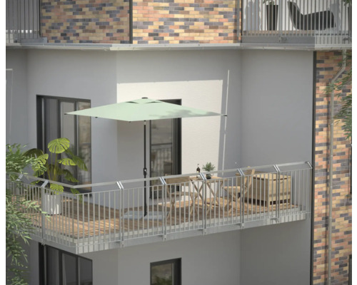 Balkon mit Sonnenschirm, Tisch, Stühlen und Pflanzen für eine entspannte Atmosphäre im Freien