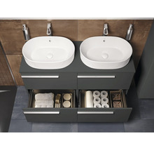 Badezimmer mit zwei Waschbecken auf einem grauen Unterschrank mit offenen Schubladen, in denen Handtücher und Toilettenpapier liegen