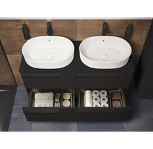 Badezimmer mit Waschbecken, Unterschrank, Armatur, Handtüchern und Badutensilien.