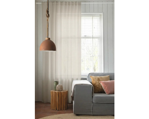 Salon avec rideau, lampe et canapé pour une ambiance lumineuse et conviviale.