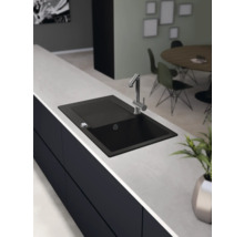 Schwarzes Spülbecken mit Wasserhahn auf einer Küchentheke.