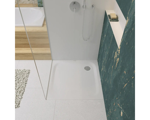 Badezimmer mit Dusche, Duschwanne, Armatur und gefliester Wand