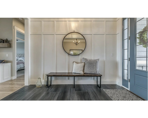 Hall d'entrée avec miroir, banc et coussins décoratifs au mur