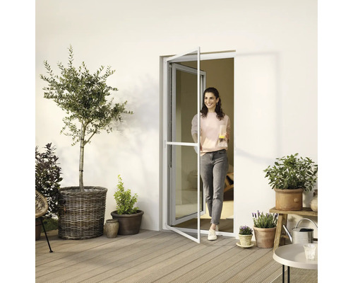 Femme entrant sur une terrasse par une porte anti-insectes