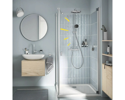 Salle de bains moderne avec douche, lavabo et miroir pour une atmosphère claire et organisée.