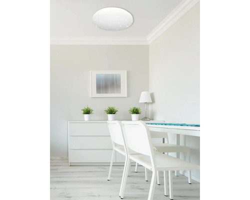 Heller Raum mit moderner Deckenspotslampe und weißen Möbeln