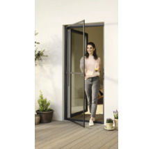 Une femme entre sur la terrasse par une porte tournante avec moustiquaire.