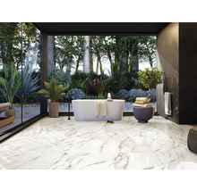 Salle de bains lumineuse avec baignoire autoportante, plantes et carrelage imitation marbre