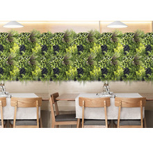 Panneau de plantes vertes décoratif comme décoration murale au-dessus d'un groupe de tables.