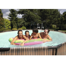Familie genießt das Schwimmen im Pool mit Poolleiter im Garten.