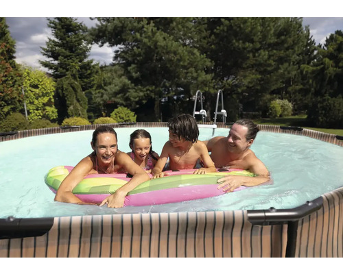 Familie genießt das Schwimmen im Pool mit Poolleiter im Garten.