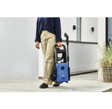 Eine Person trägt einen Nilfisk Hochdruckreiniger.