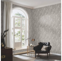 Wohnzimmer mit gemusterter Tapete, Sessel und Fenster