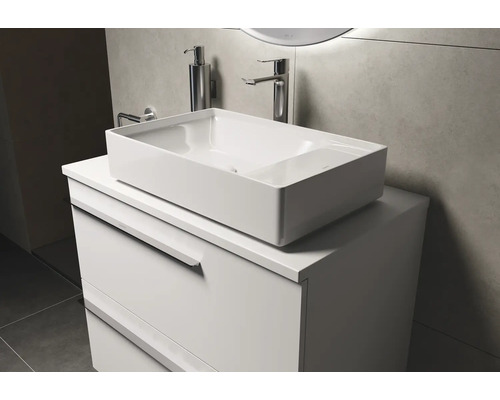 Un lavabo à poser rectangulaire en céramique est posé sur un meuble-lavabo blanc.