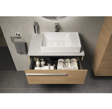 Salle de bain avec lavabo, meuble à tiroirs ouvert et serviettes