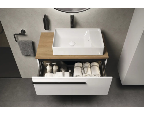 Meuble-lavabo avec tiroir ouvert, serviettes et produits de soins