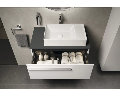 Salle de bains avec meuble-lavabo, lavabo et tiroir ouvert avec serviettes et produits de soins