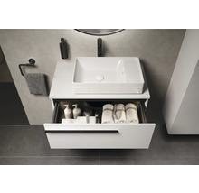 Meuble-lavabo avec tiroir ouvert, serviettes et produits de soin dans une salle de bains